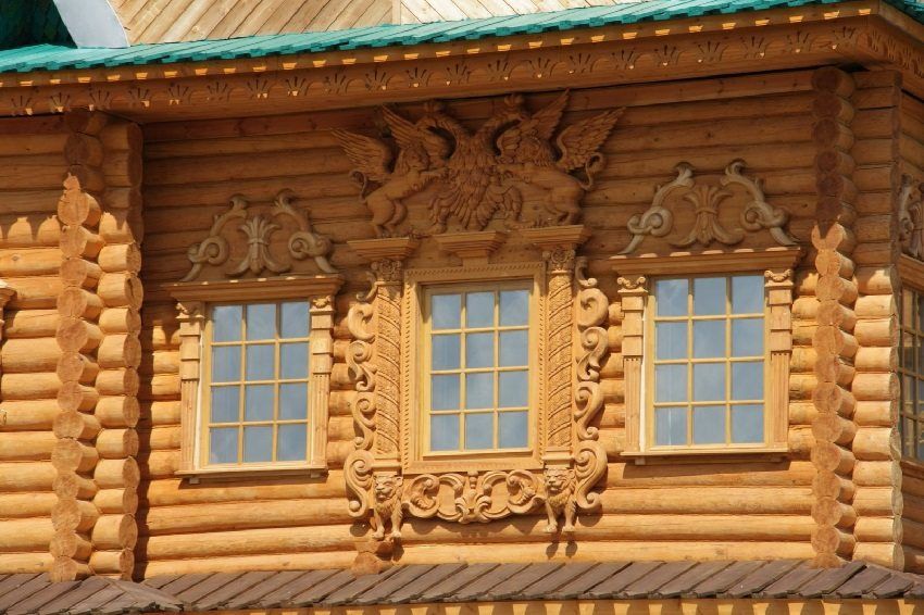 Platbands op de ramen in een houten huis: extra decoratie van de gevel